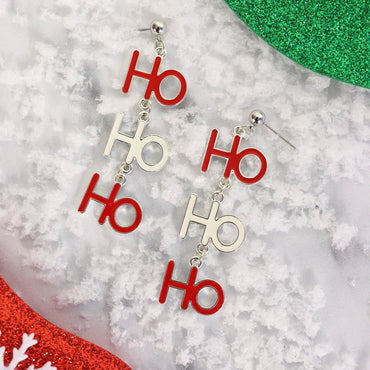 red and white ho ho ho slogan earrings styled on white snow covered background