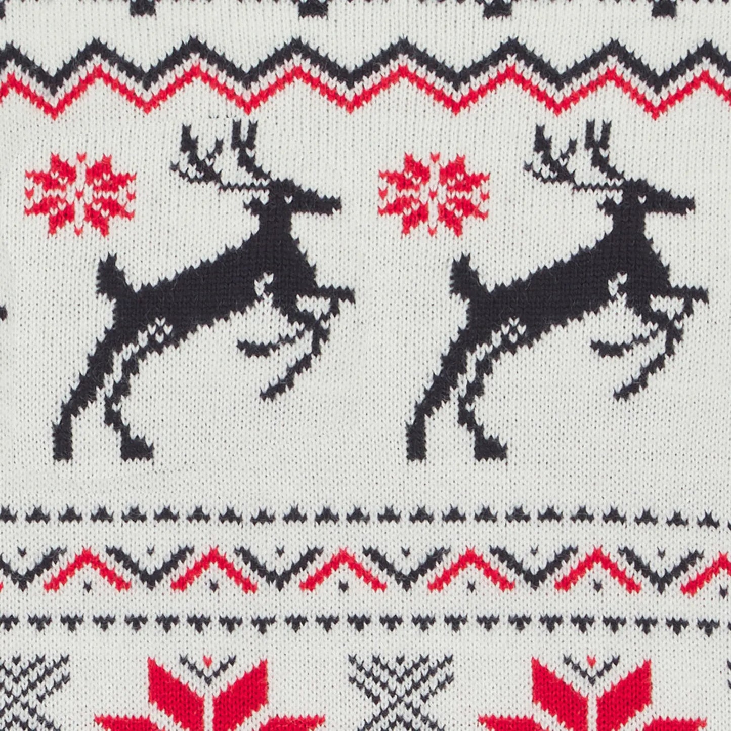 detail shot of embroidered reindeer, snowflake and zig zag design on white jumper