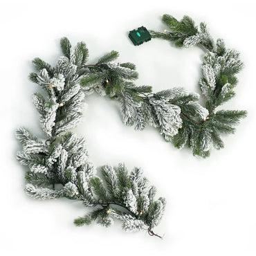Snow flocked green pine Christmas garland lit with battery operated warm white fairy lights