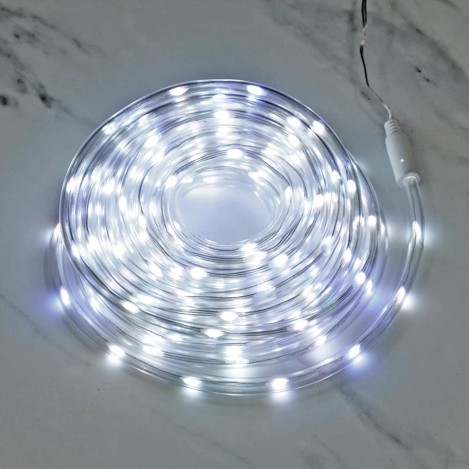 Coil of cool white LED rope light lit up on a marble floor