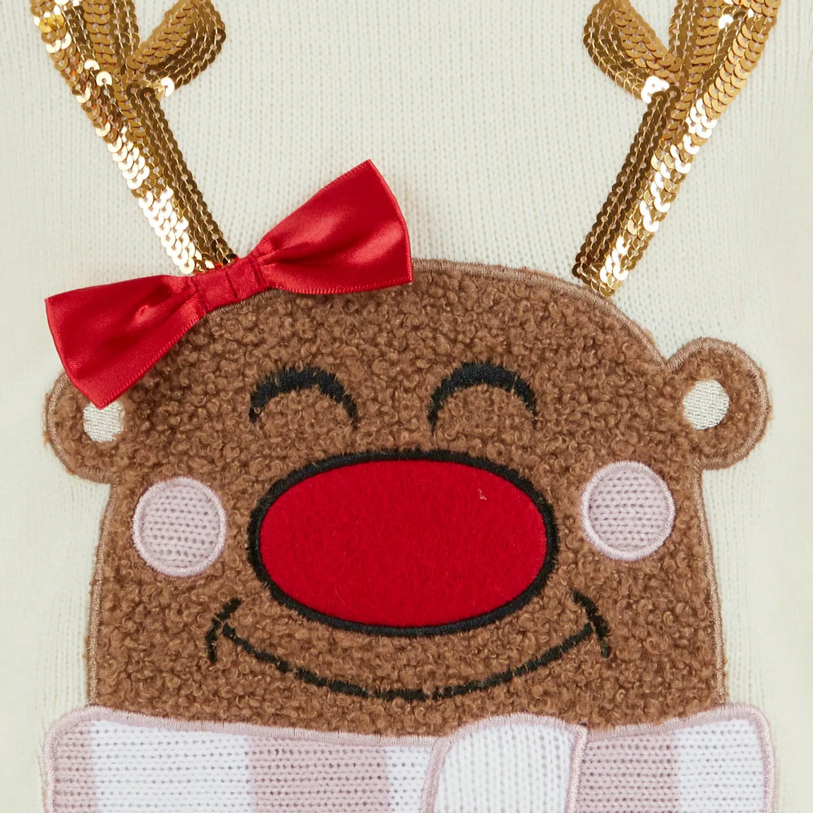 detail shot of reindeer character face featuring 3D red satin bow, gold sequin antlers and large embroided red nose
