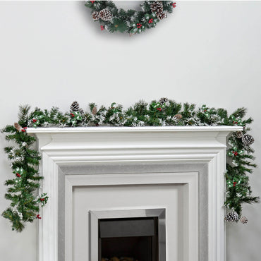 Luxury Frosted pine Christmas garland with pine cones and red berries on a white mantelpiece