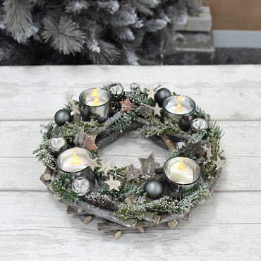 Mr Crimbo Christmas wreath candle holder with grey twigs, silver baubles and stars, and green foliage