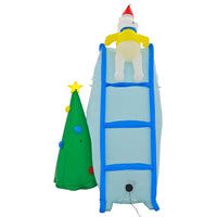 Back view of Christmas inflatable decoration with blue ice slide, ladder and polar bear with yellow jacket and red hat beside a green Christmas tree