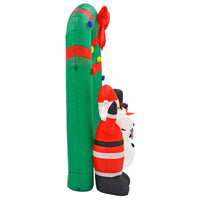 Side view of a large inflatable Arch Christmas decoration with Santa and snowman, green garland style arch with red bow