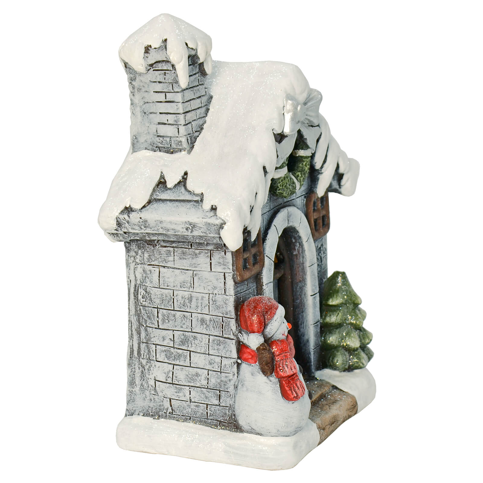 Side view of Christmas ornament with snowman and tree at the door of a snow covered, grey brick house with Christmas wreath