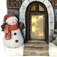 Close up detail of snowman at the door of a house with LED stars Christmas ornament