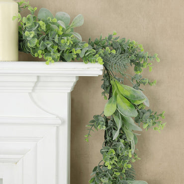mr crimbo mixed green christmas garland draped of white fireplace mantel, style with pillar candles on sand colour wallpaper